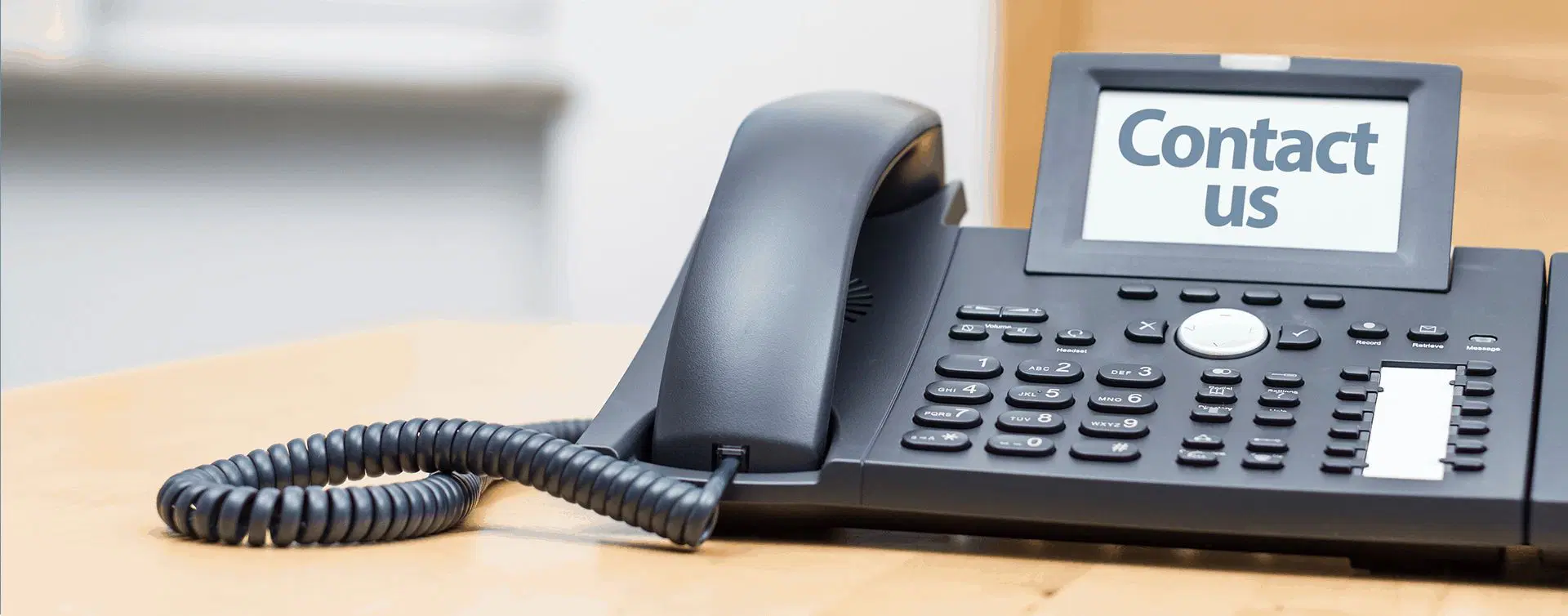 desk phone with the words Contact Us on the digital screen