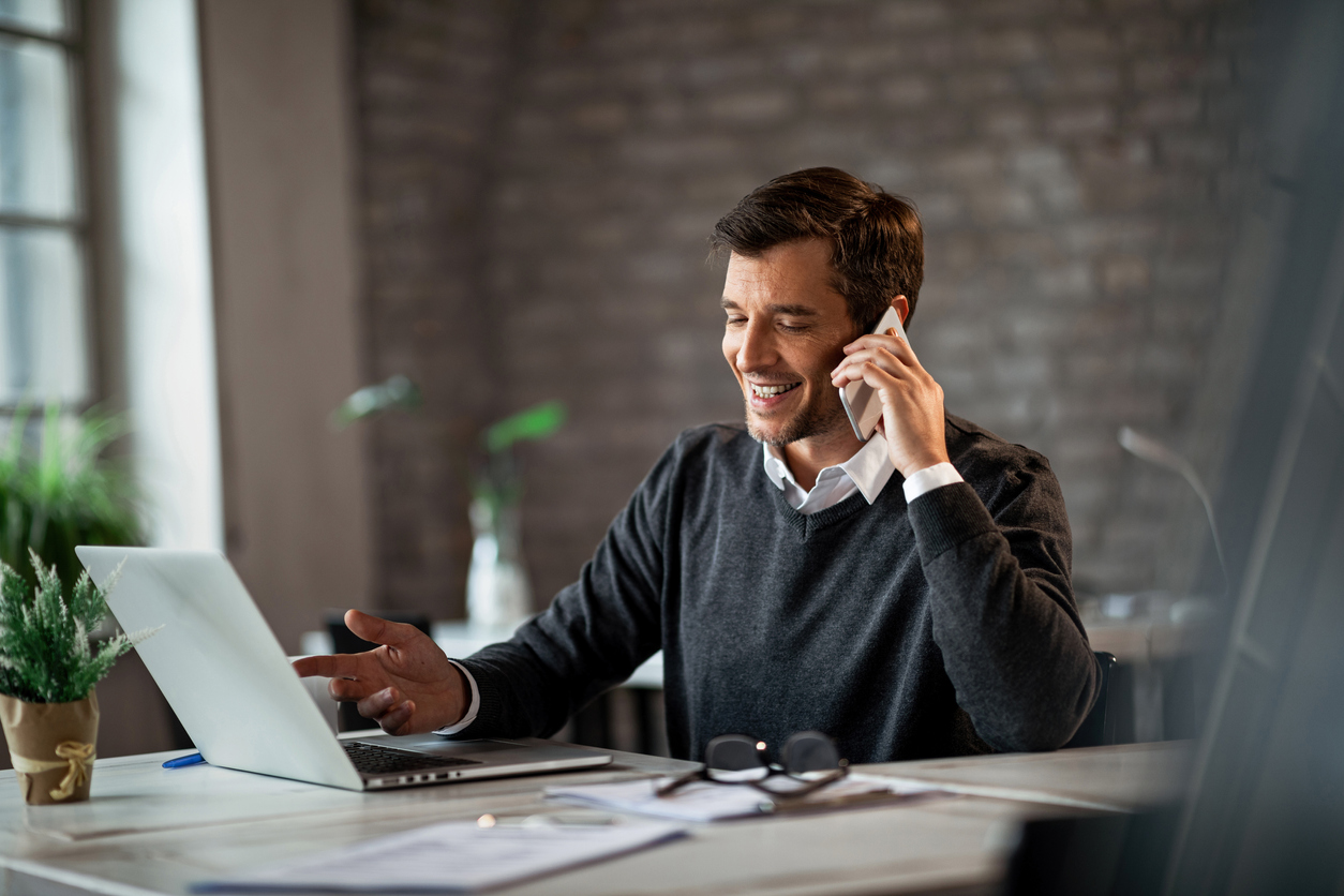 business man talking on the phone using his laptop