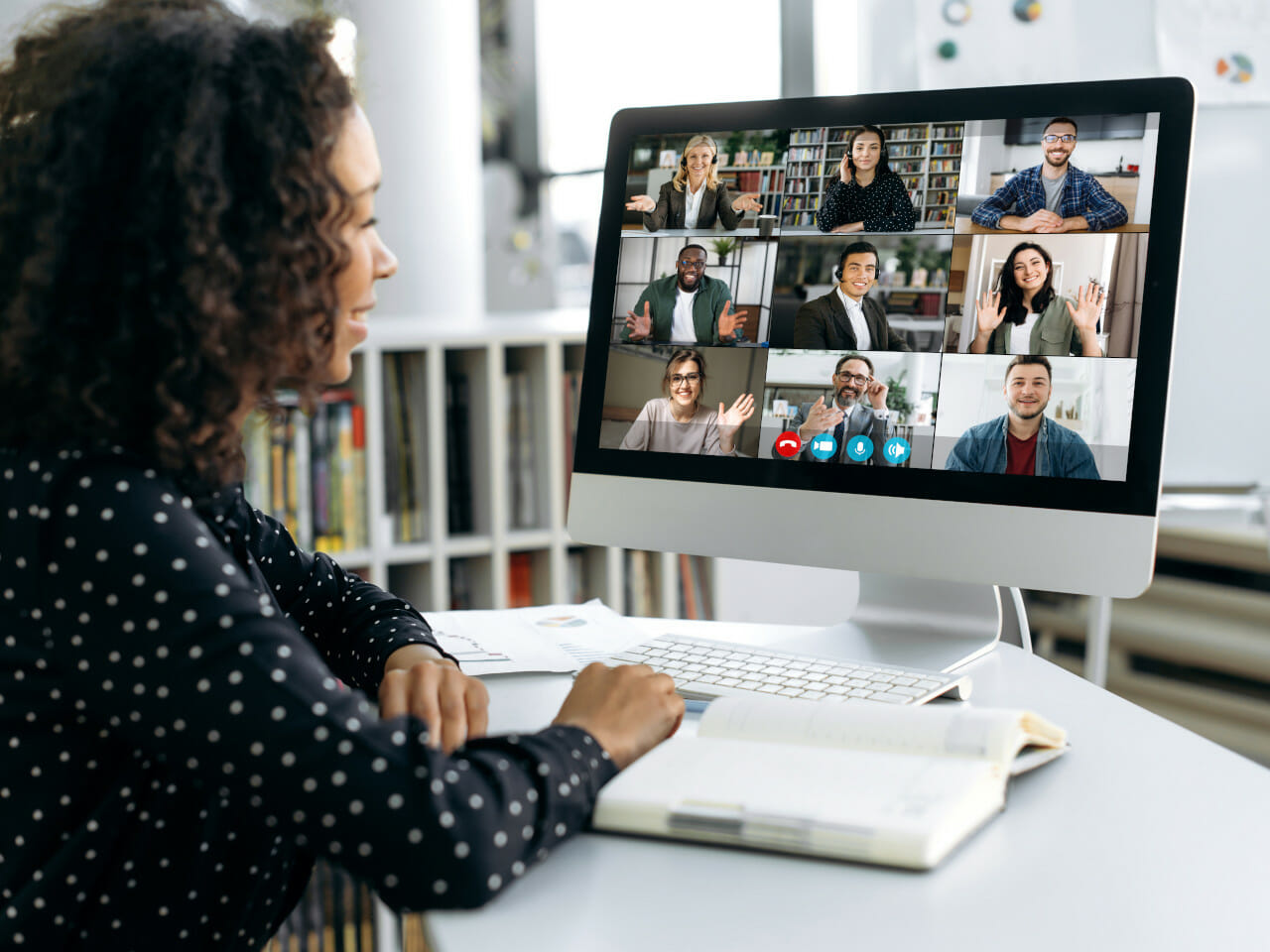 A woman sitting in front of a computer with several people on a video conference.