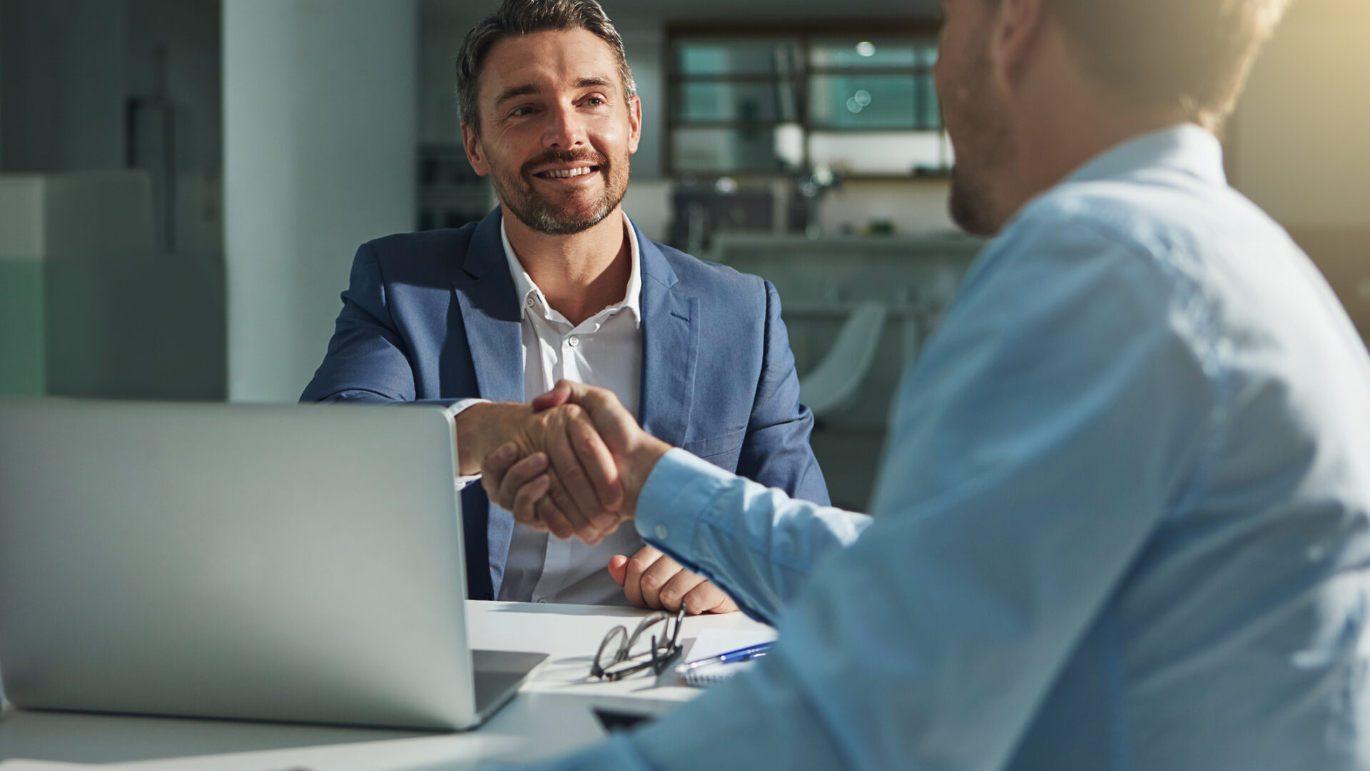 Man in a suit shaking hands with another man