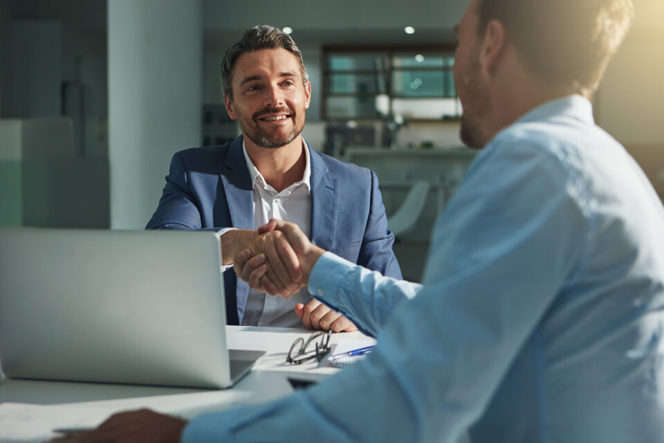 Man in a suit shaking hands with another man